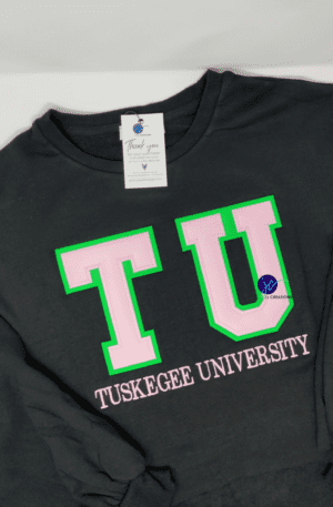 A Black on Black AKA Embroidered Unisex Sweatshirt with “TU Tuskegee University” in bold pink and green letters on the front, displayed on a flat surface. Perfect for showing your Alpha Kappa Alpha Soror pride.