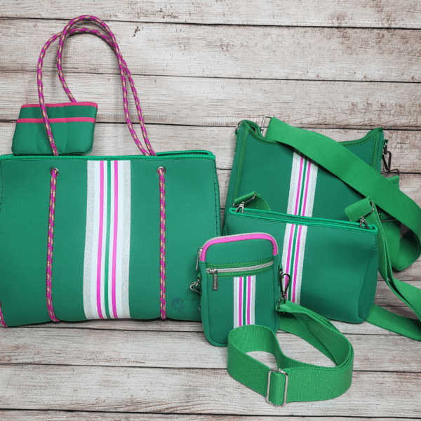 A collection of STAR Neoprene Messengers With 2” Adjustable Self Strap Included with white, pink, and green stripe accents, including a tote, crossbody bag, small pouch, and small crossbody phone bag displayed against a wooden background.