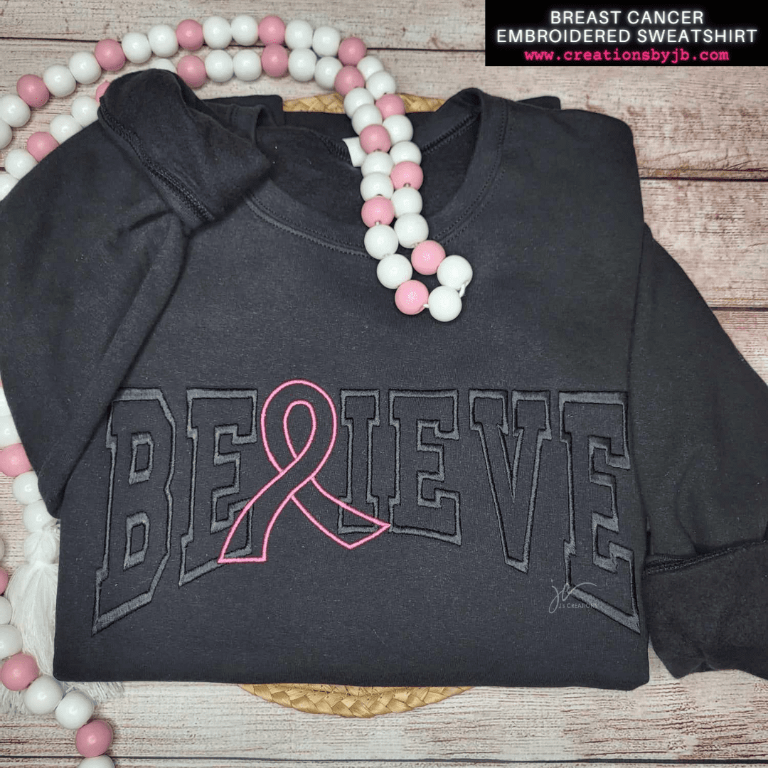 A black sweatshirt with breast cancer awareness on it.