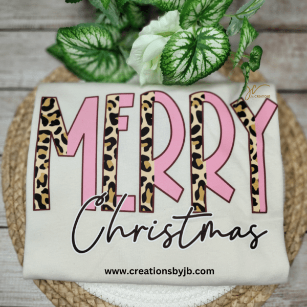 A merry christmas shirt with leopard print and pink lettering.