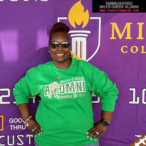 A woman in green shirt standing next to purple wall.
