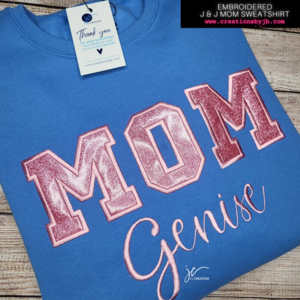 A blue shirt that says mom genise on it.