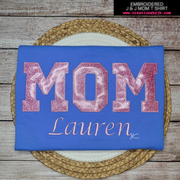 A blue shirt with the word mom written in pink letters.