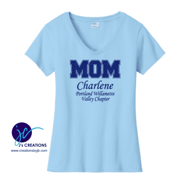 Light blue V-neck T-shirt with "MOM" in large navy letters, "Charlene" and "Portland Willamette Valley Chapter" in smaller text, and the "J's Creations" logo on the side. Inspired by the Jack And Jill MOM Ladies V-Neck Glitter Vinyl T Shirt, this tee offers a stylish nod to community pride.